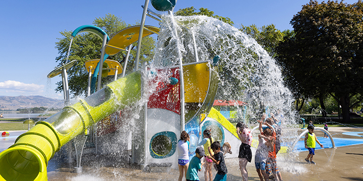 Children playing the in spray of a large multifeature splash pad structure 