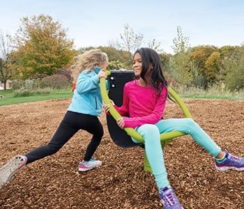 Two girls play on playground Chill Spinner