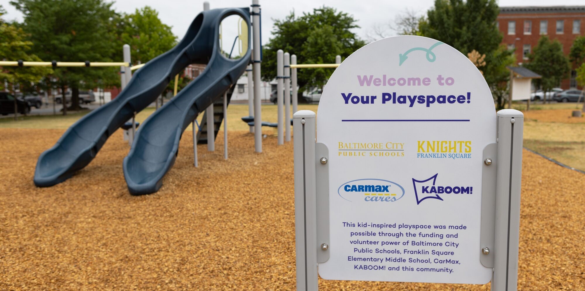 KABOOM! sign in front of blue playground slides