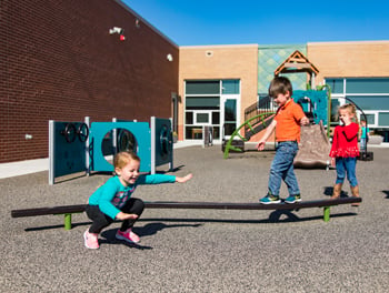 Children on balance beam on outdoor playground