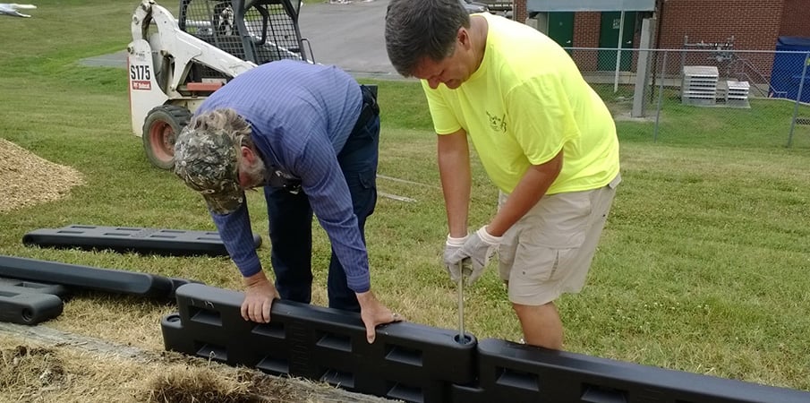 Playground Building volunteers installing TuffTimbers playground edging."
