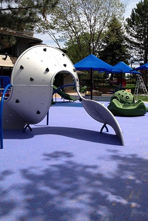 A silver Mobius climbing structure on an indigo safety surface. 