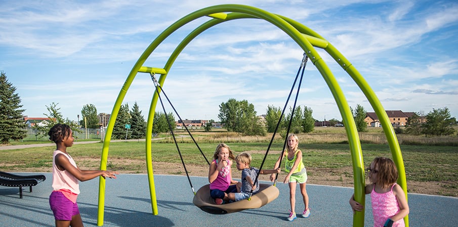 Five kids play together on a Oodle swing.