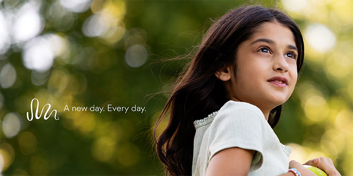 Cover of catalog showing girl looking to the side with trees in background 